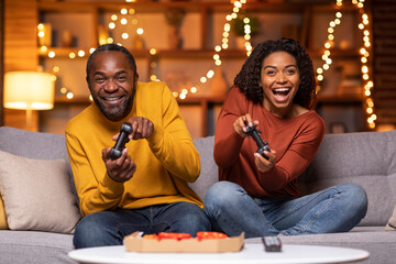 Emotional black couple playing video games at home