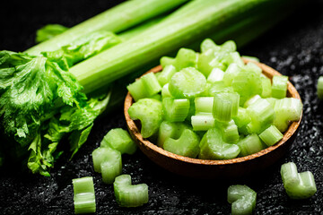 Pieces of celery in a wooden plate on the table.