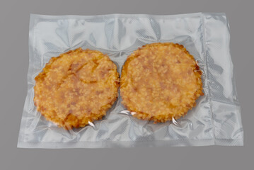 Chicken fillet breaded burger in vacuum packed sealed for sous vide cooking isolated on Gray background in top view