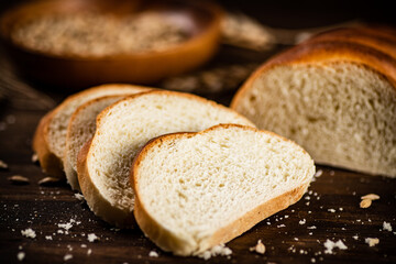 Sliced wheat bread. On a wooden background.