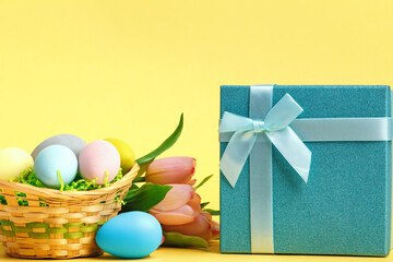 Easter composition. Basket with eggs box with a gift on the table