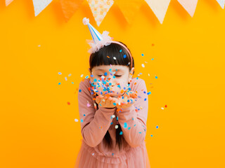 happy birthday children girls with confetti on colored yellow background