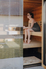 Frau sitzt in finnischer Sauna