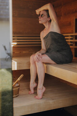 Frau sitzt in finnischer Sauna