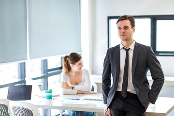 Handsome businessman working on laptop in bright modern office