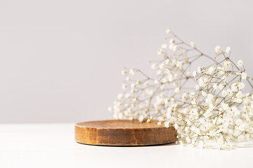 Beauty cosmetic product presentation scene made with a wooden plate and wild flowers. Summer mood background. Front view.