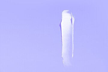 White cream smear on a purple background. High resolution photography.