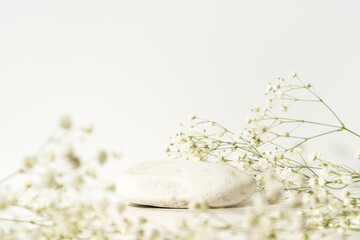 Beauty cosmetic product presentation summer template made with white stone and flowers.