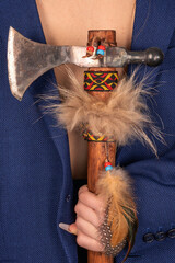 In the hand of the young lady behind her back is a tomahawk. Close-up...