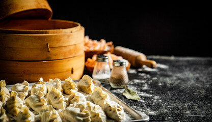 Homemade raw dumplings gyoza with shrimp on a baking sheet. 