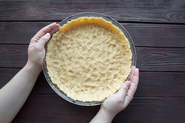 Raw shortcrust pastry on brown table background, raw dough, top view. 