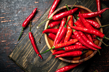 Red chili pepper pods on a cutting board.