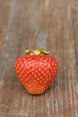 Macro view of strawberry on the wooden background. Gardening concept.