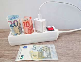 Energy concept with power extension cord and euro currency – the cost of electricity is more expensive due to energy global crisis. Selective focus.