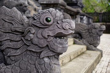 Sculpture dragon heads with stone eyes on the side of the stairs in Khai Dinh Mausoleum, Hue, Vietnam                            