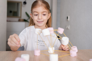 Child girl make chemistry science molecular model at home. 