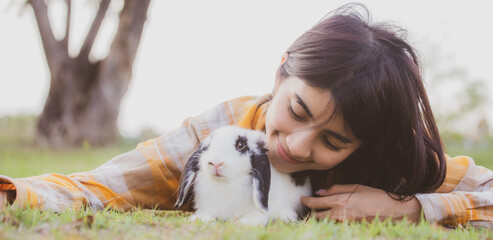 relationships of cheerful rabbit and happy young human girl, domestic friendship family of little cute easter pet and friends person having smile and fun, animal love and care at home concept