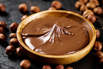 Hazelnut butter with peeled hazelnuts on the table. 