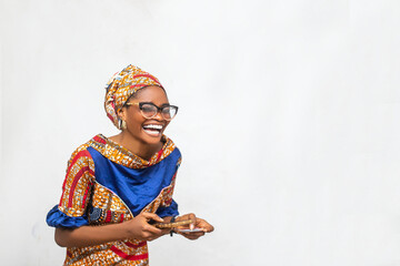 African woman isolated over white background laughing holding phone and credit card