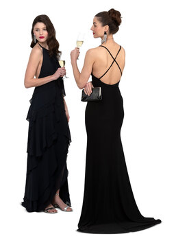 Two elegant women in long black evening gowns attending a party and drinking champagne, isolated on white background
