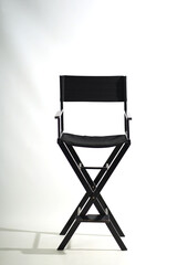 Black wooden folding chair on a white background.