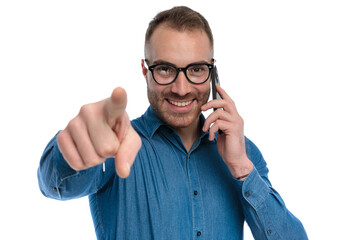 attractive bearded guy with glasses talking on the phone and pointing finger