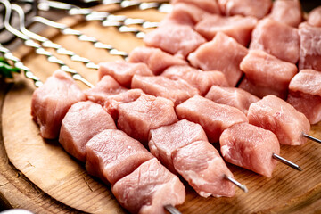 Pork raw kebab on a cutting board.