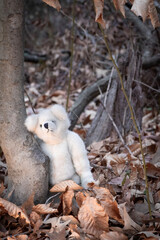 teddy bear leaning on a tree