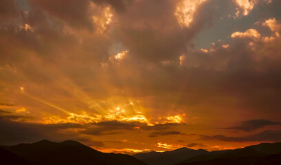colorful sunset on top of Caucasian mountains. Sunset in mountain over peak. Sun light and early morning or evening mountain sky background. Dilijan, Armenia,