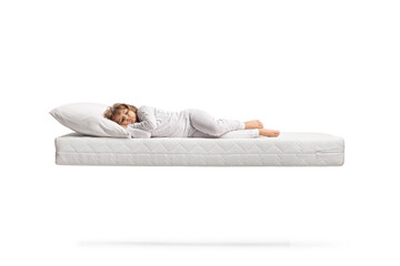 Little girl in pajamas sleeping over a flying mattress