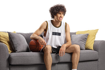 Guy in a sports jersey with a baskteball sitting on a sofa