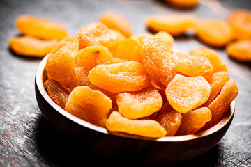Full wooden plate with dried apricots. 
