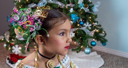 Girl in front of a Christmas tree. 