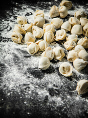 Raw dumplings on the table with flour.