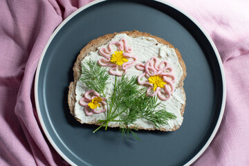 creative sandwich with soft cheese and pink pasta tarama greens, flowers
