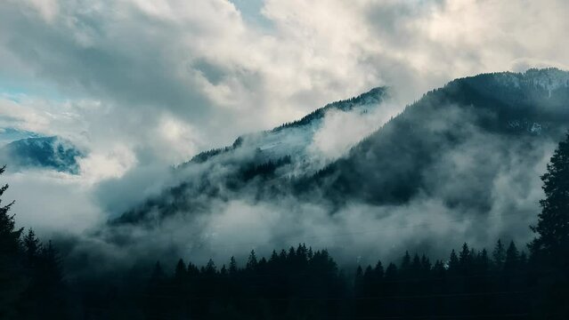Fog and clouds curl on the fores covered slopes of the Swiss Alps near Lucerne, time lapse. Switzerland