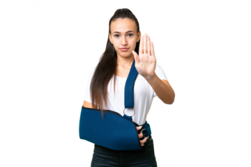 Young Arabian woman with broken arm and wearing a sling over isolated chroma key background making stop gesture