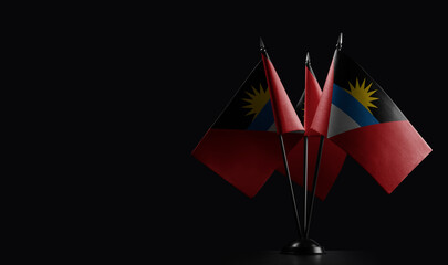 Small national flags of the Antigua and Barbuda on a black background