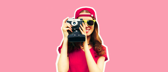 Portrait of happy smiling young woman photographer taking picture on film camera wearing red baseball cap on pink background, magazine style