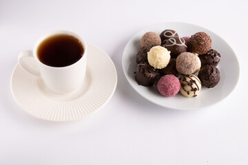 photo of candy on a plate and a cup of coffee
