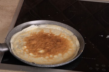photo of a pancake lying in a frying pan and frying