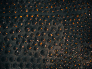 Aerial view of black volcanic wine yards in Lanzarote, taken by drone. Top view of grape inside the holes in volcanic field - La geria (Lanzarote).