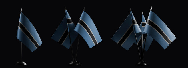 Small national flags of the Botswana on a black background