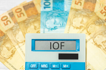 A sigla IOF de Imposto sobre Operações Financeiras escrita no visor de uma calculadora. Economia...