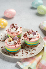 Easter mini cheesecakes with candy eggs and whipped cream.