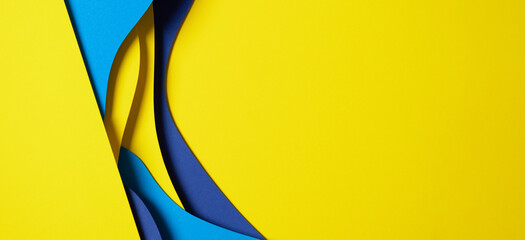 Abstract colored paper texture background. Minimal paper cut composition with layers of geometric shapes and lines in light blue, navy blue, yellow colors
