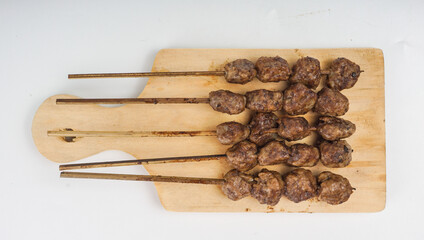 Grilled meatballs (bakso bakar), isolated on white background. Traditional food from East Java, Indonesia.