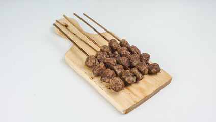Grilled meatballs (bakso bakar), isolated on white background. Traditional food from East Java, Indonesia.
