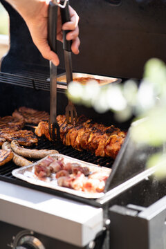 Unrecognizable Man Grilling Meat In The Backyard.