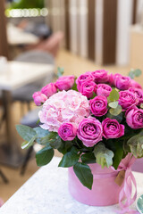 a bouquet of flowers on the table and a cup of coffee